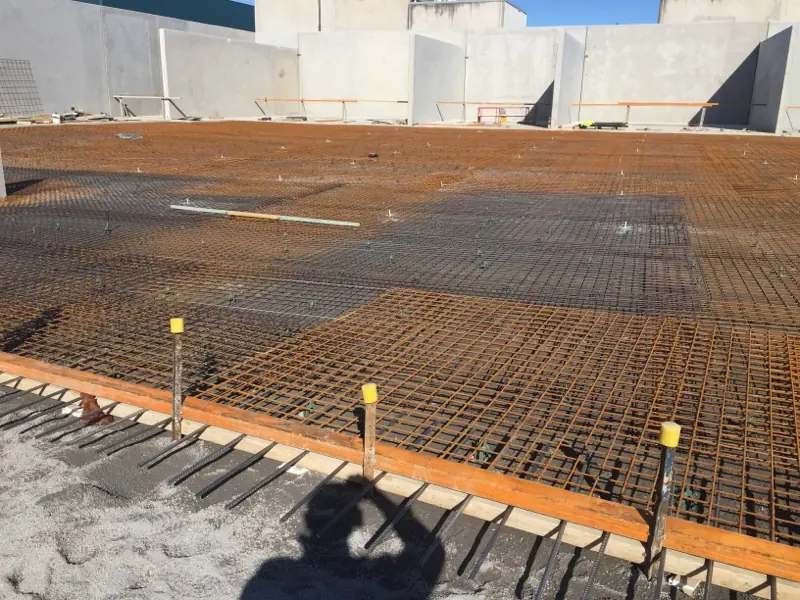 Extensive reinforcing steel grid laid out over a large area, prepared for a concrete pour at the Kirawee site.