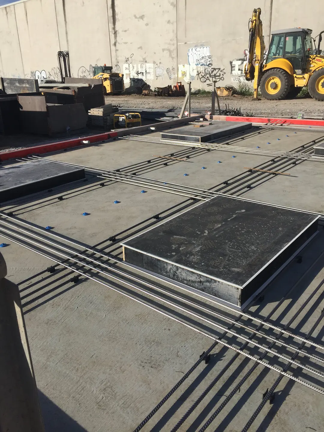 Precast concrete slabs laid out on the ground with rebar frames, ready for installation at the Kirawee construction site.